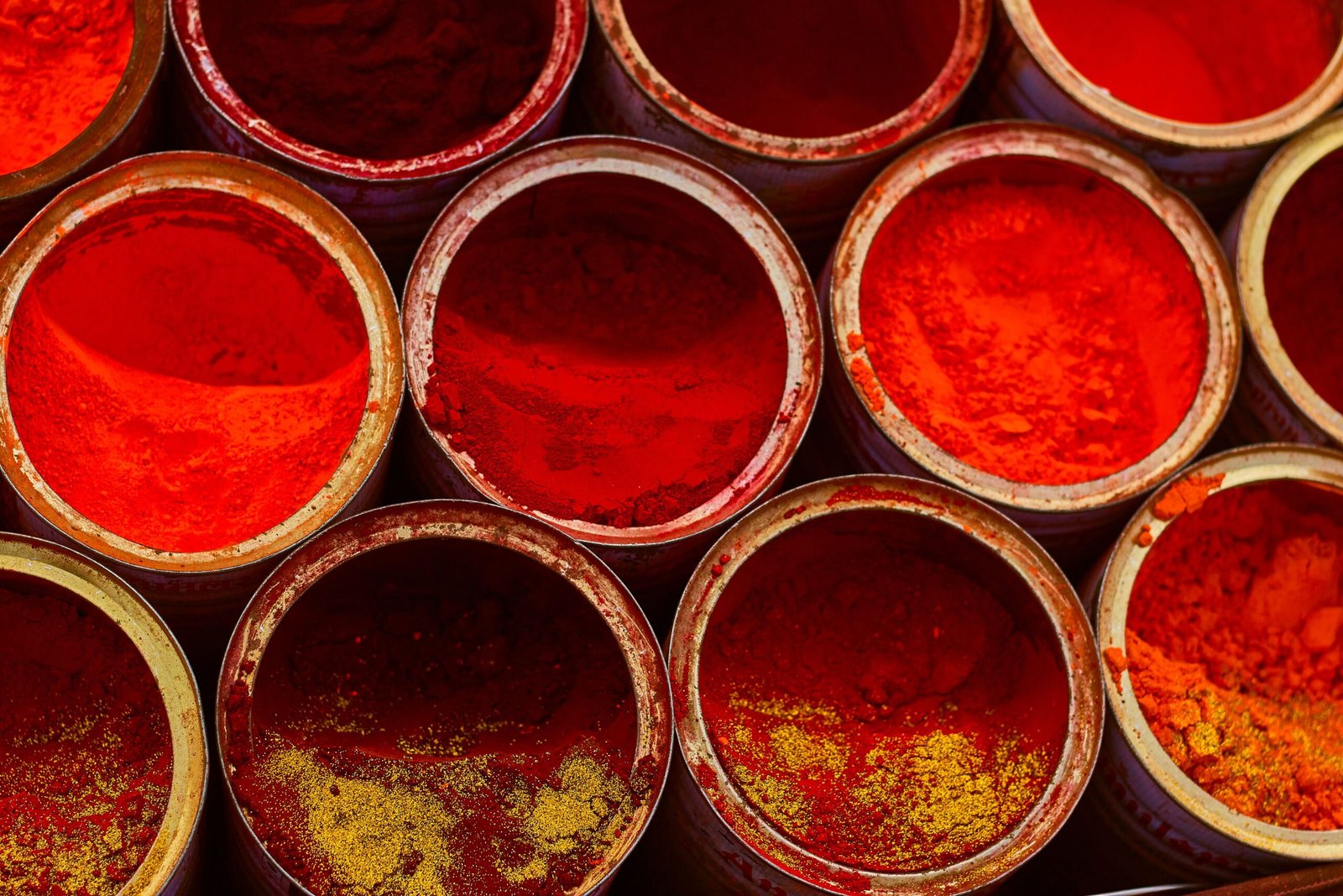 Home Top view of colorful spices in bowls showcasing various shades of reds and yellows.